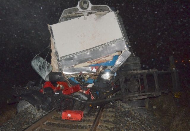 Zničený nákladní vůz před vlakem