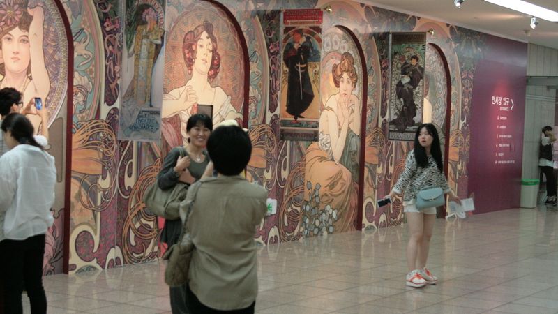 Korejci si fotí vstup na Muchovu výstavu.