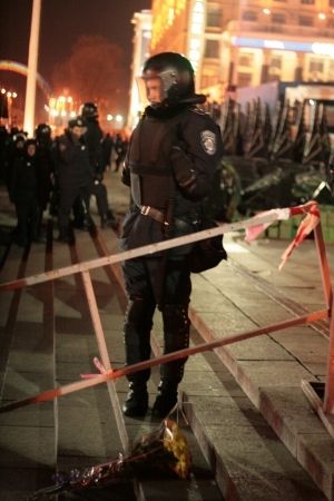 Kytice u nohou policisty střežícího střed kyjevského Náměstí nezávislosti