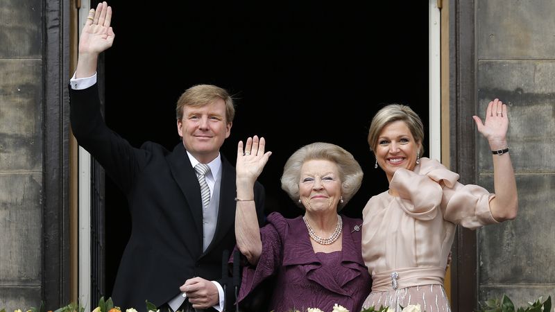Královská rodina zdraví davy z balkónu paláce v Amsterdamu.
