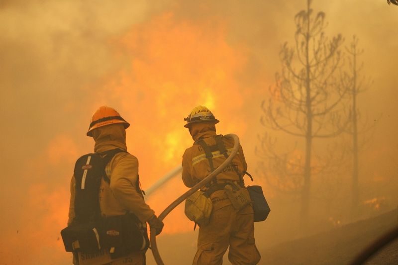 Kalifornští hasiči bojují se zuřícím požárem.