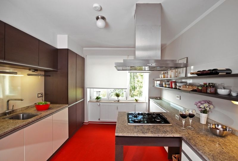 Kuchyň barevně oživuje nápadný odstín červeného marmolea, které je příjemné na dotek a dobře se udržuje. Kuchyňská linka je od německého výrobce Leicht a deska ze žuly Kashmire White. 