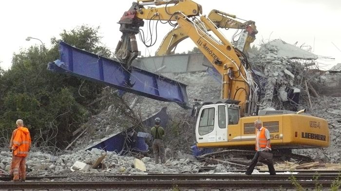Stavbaři likvidují kusy spadlého mostu ve Studénce na Novojičínsku.
