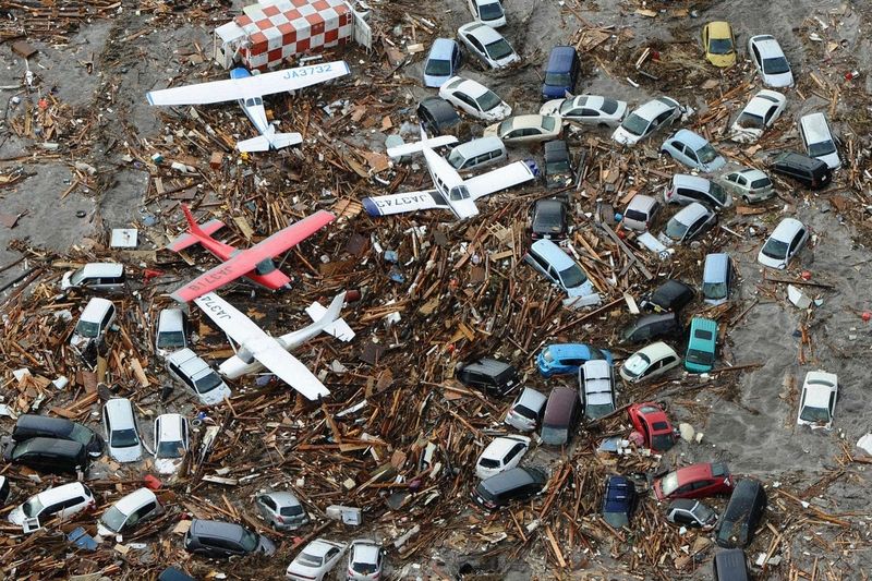 Letadla, auta, trosky - vše spláchla tsunami na jednu hromadu.