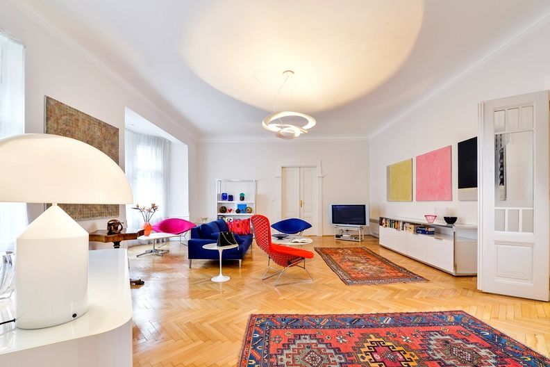 V obývacím pokoji se skvěle vyjímají designové ikony z poloviny minulého století (stolky Eera Saarinena, křesla Bertoia) a dobře si rozumí s moderním nábytkem, svítidlem i uměleckým sklem a obrazy Tomáše Rajlicha (vpravo triptych Nebe, Peklo, Ráj).
