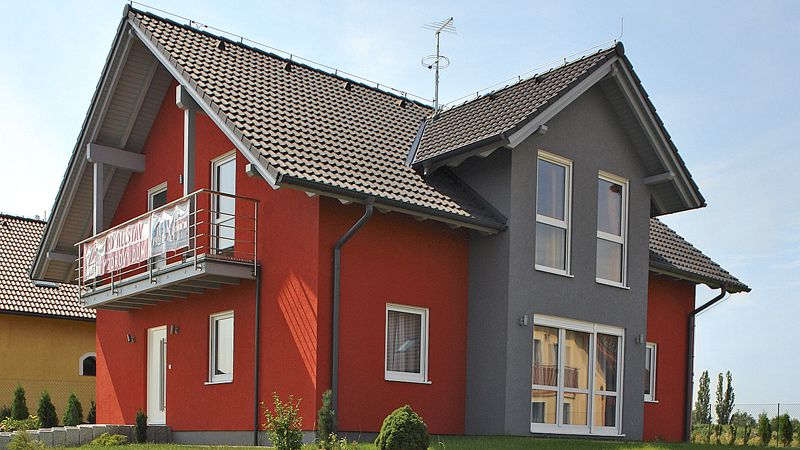 Přízemní dům s nízkou sedlovou střechou nijak neruší okolní zástavbu, jediným výraznějším prvkem jsou plochy červeně natřené omítky. 