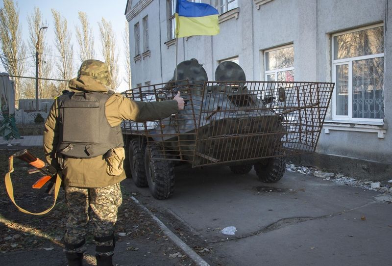 Obrněné vozidlo ukrajinské armády před jednou z volebních místností ve městě Volnovacha na východě Ukrajiny