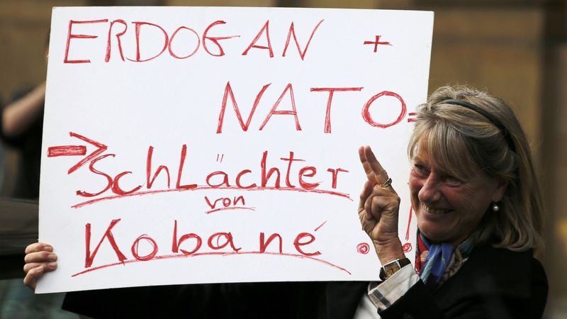 Žena drží protestní ceduli s nápisem Erdogan + NATO = řezníci Kobani na demonstraci na podporu syrských Kurdů v německém Düsseldorfu.