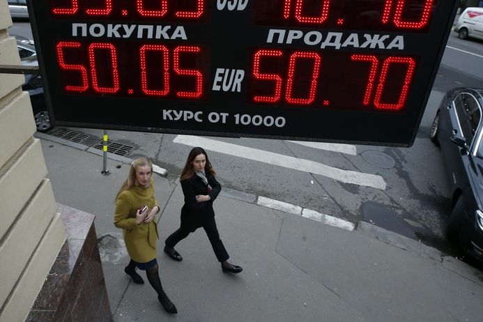 Ženy procházejí okolo směnárny v Moskvě.