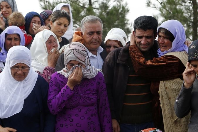 Kurdští uprchlíci z Kobani oplakávají své mrtvé.