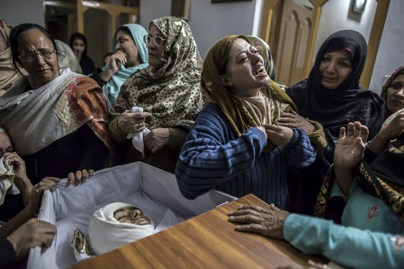 Ženy oplákavají patnáctiletého chlapce zabitého při útoku Tálibánu ve škole v Péšávaru.