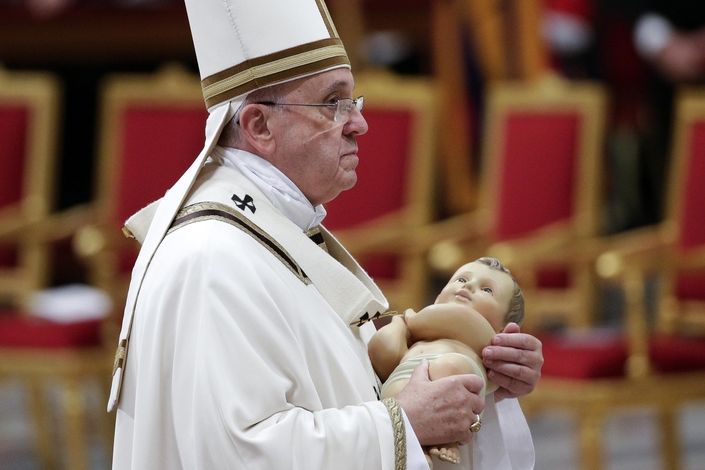 Papež František drží na závěr vánoční mše sošku Ježíška 