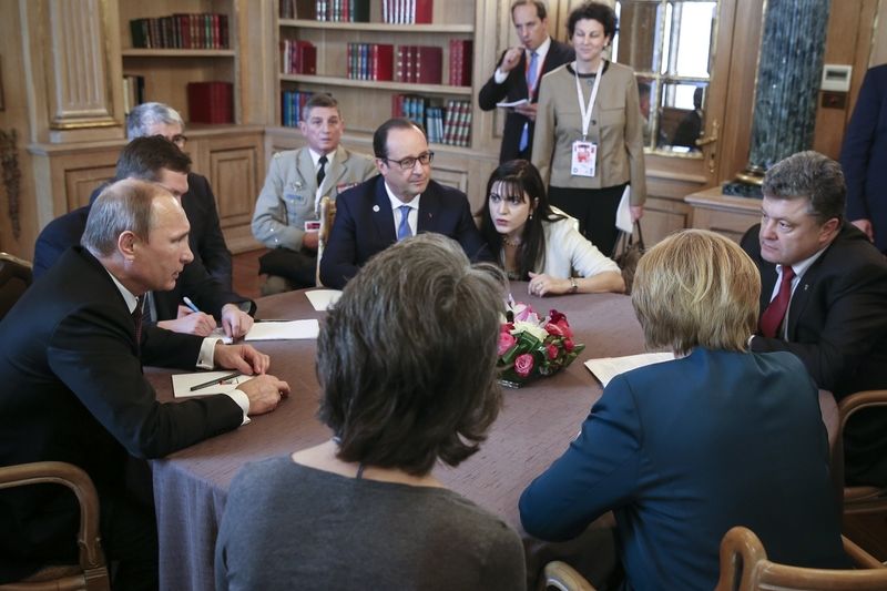 Ruský prezident Vladimir Putin s ukrajinským protějškem petrem Porošenkem. Mezi nimi je francouzský prezident Francois Hollande.