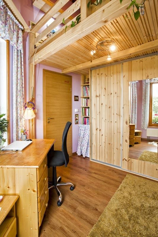 Nábytek z masivního dřeva a vestavěné skříně s dřevodekorem zapadají do přírodního stylu interiéru.
