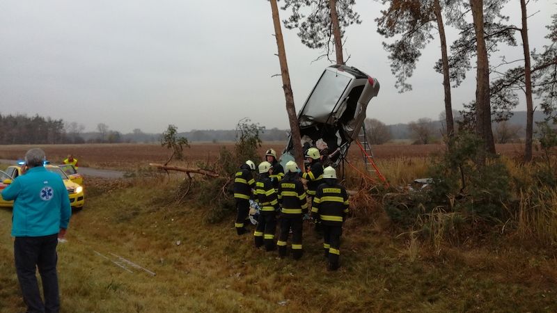 Auto zůstalo po nehodě mezi dvěma stromy