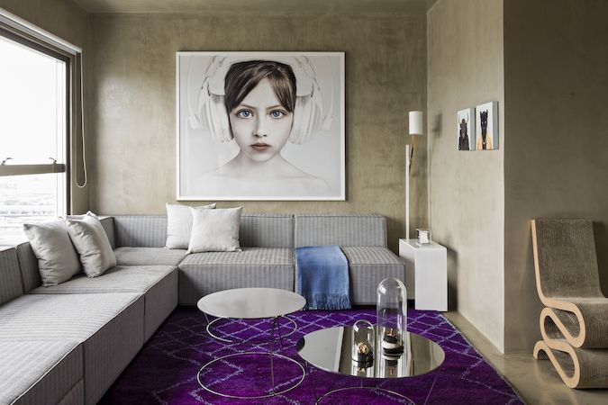 V bytě mladého umělce se zajímavým způsobem doplňuje šedá barva stěn, stropů a podlah s prvky ve fialové, růžové burgundské červené.