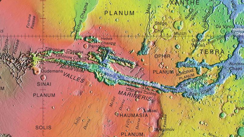Výšková mapa povrchu Marsu v nepravých barvách ukazující pozici systému kaňonů Valles Marineris. Modrá barva označuje oblasti s nejnižší výškou, červená s nejvyšší.