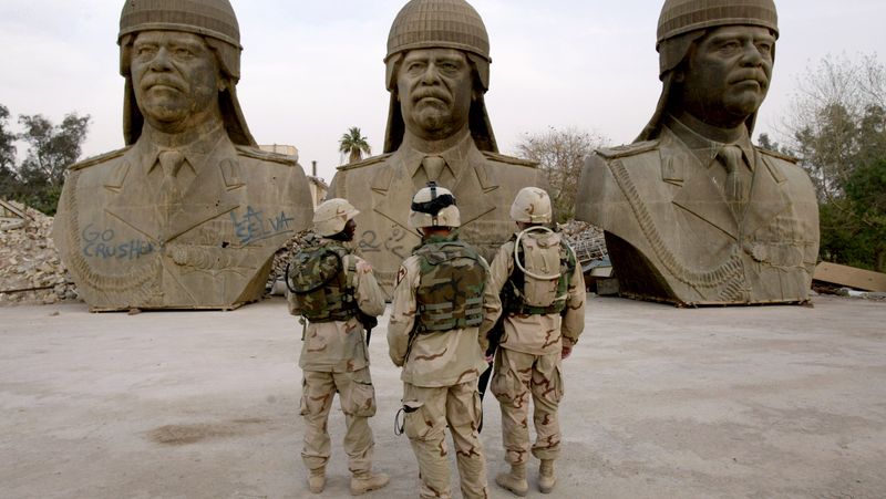 Američtí vojáci a busty Saddáma Husajna, Irák, březen 2004