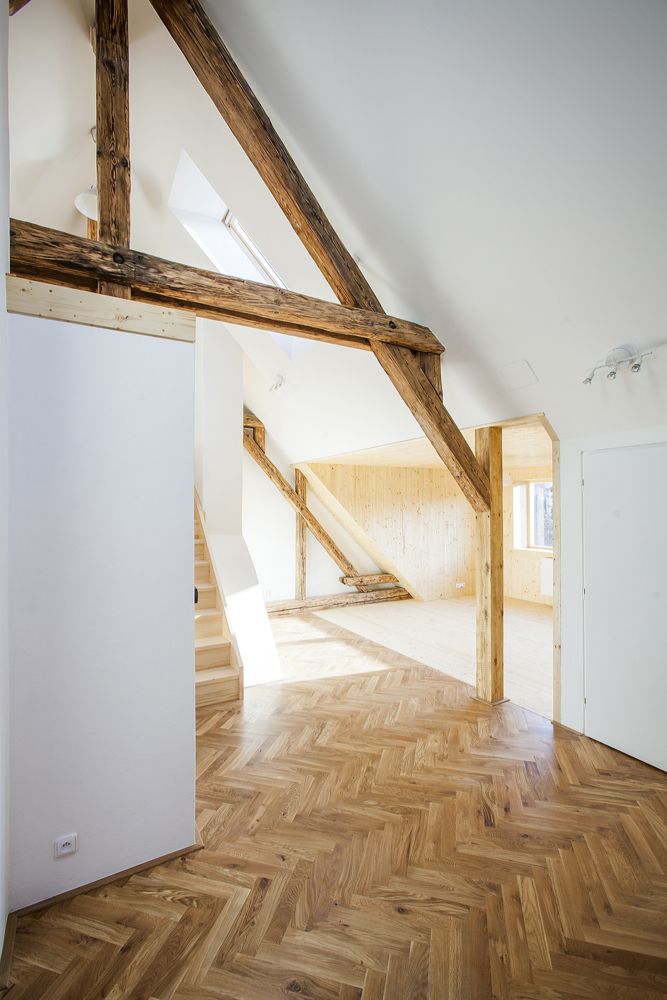 Původní krokve s originálními stopami stáří skvěle korespondují s bělostnou čistotou stěn a nachází svůj analogický odraz v dřevěné vlisové podlaze i v dřevěném obložení. 
