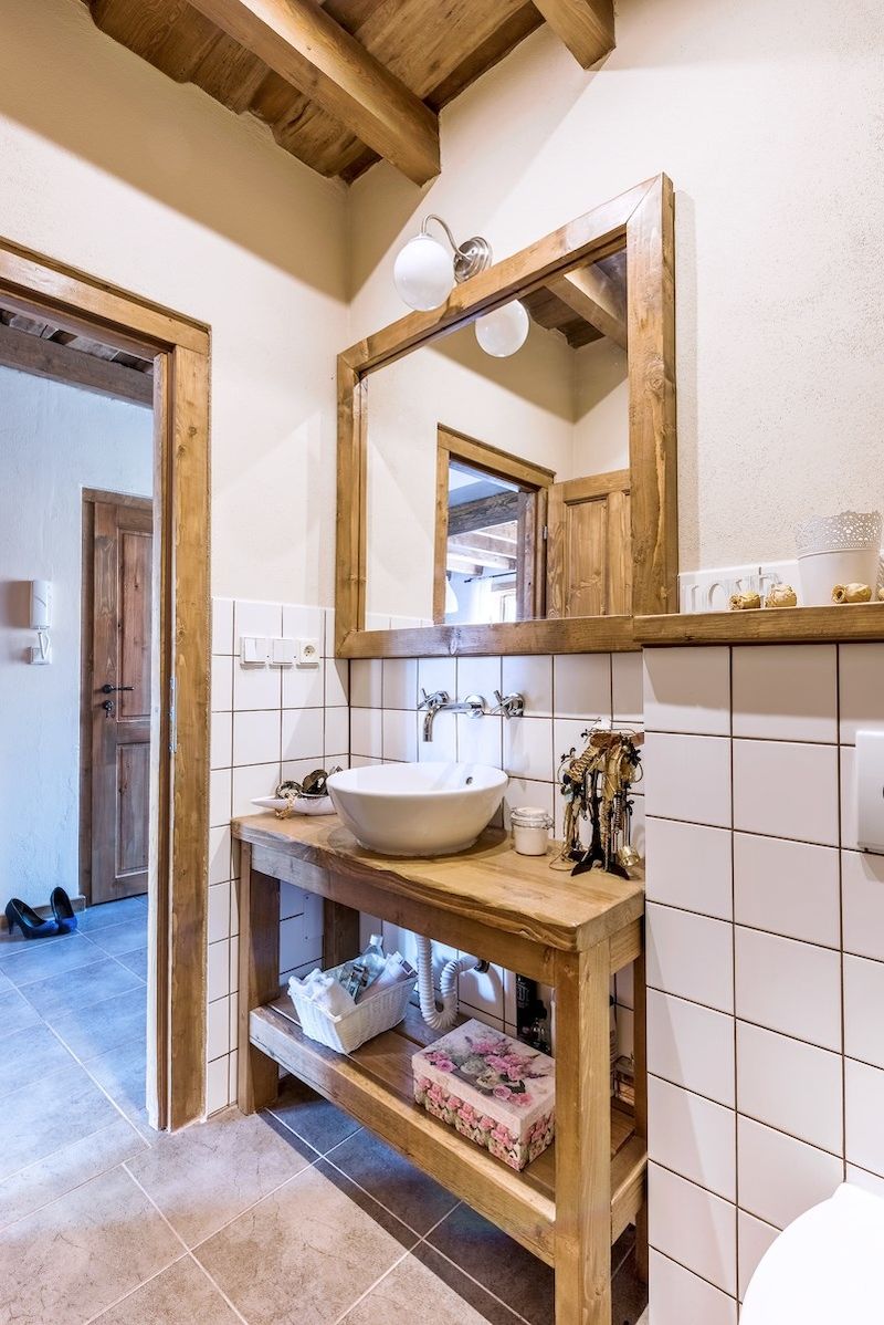 Koupelna je vybavená umyvadlovou skříňkou, toaletou a sprchovým koutem. Nábytek pochází opět z majitelovy dílny. 