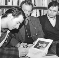 Na křtu knihy o dědečkovi Rudolfovi podepisuje Rudolf Hrušínský nejmladší jeden ze svazků. Vedle něj sedí táta Rudolf a strýc Jan. Snímek z první poloviny 90. let