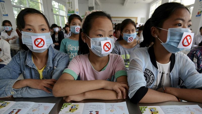 Čínské školačky s rouškami se symbolem zákazu kouření 