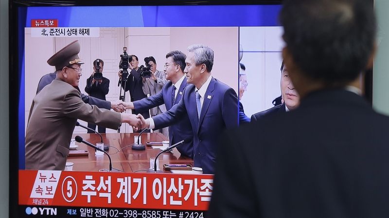 Muž sleduje televizní zprávy, které informují o dohodě severokorejských a jihokorejských představitelů.