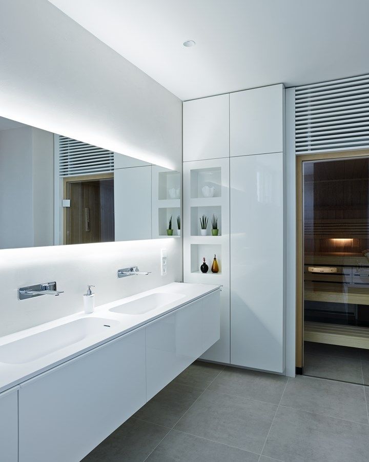 Koupelna v patře domu je vybavená umyvadly z materiálu Cristalplant a skříňkami Falper, podomítkovými bateriemi Gessi a zrcadlem Agape. Součástí místnosti je sauna Klafs.