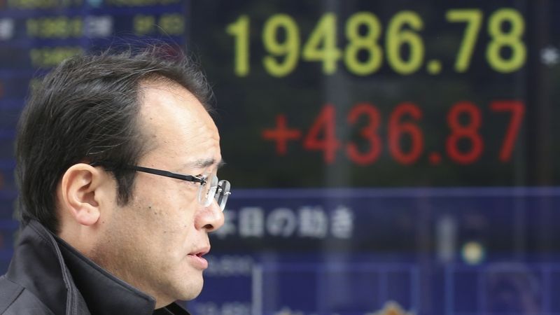 Japonec míjí panel ukazující růst indexu Nikkei 