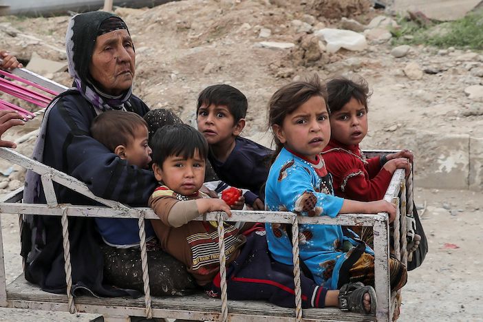 Žena s dětmi prchající během války proti Islámskému státu z iráckého Mosulu