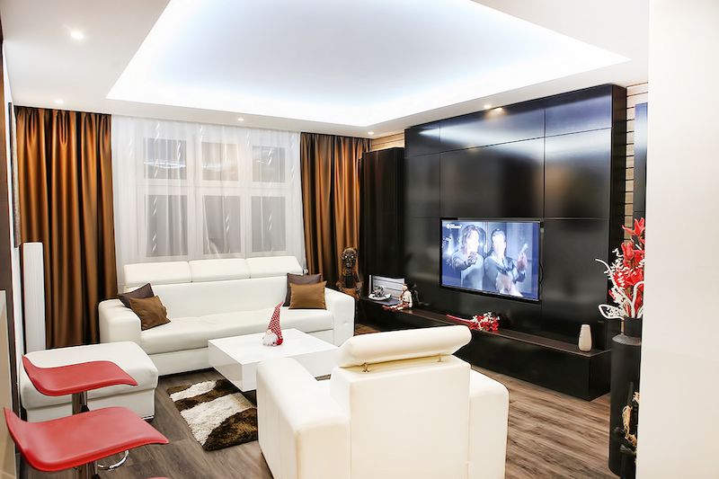 V obývacím pokoji zajímavě kontrastuje černá televizní stěna s bílou sedačkou.