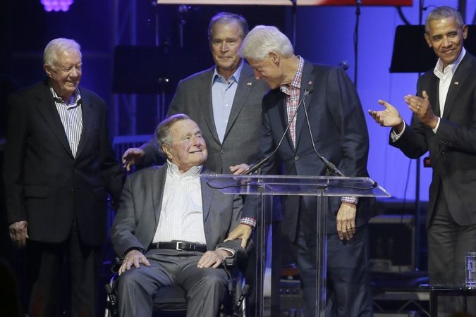 Bývalý prezident George H. W. Bush na invalidním vozíku obklopen dalšími bývalými prezidenty USA Barackem Obamou, Billem Clintonem, Georgem W. Bushem a Jimmym Carterem