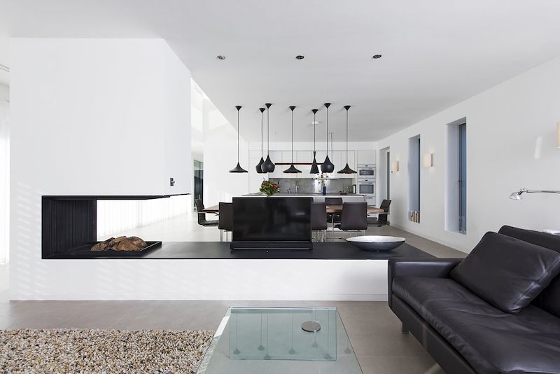 Společnou obývací část domu prostorově člení atypický otevřený krb z desek z černého plechu.