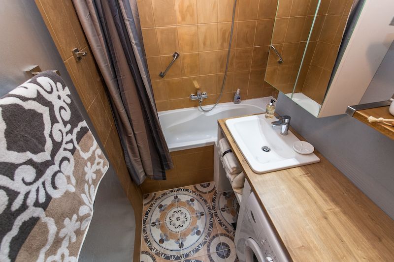 Středomořský charakter dodávají koupelně a toaletě dlaždice na podlaze a zlatavá barva, jíž majitelka přetřela keramické obklady na stěnách.