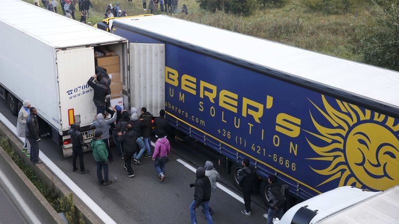 Lidé šplhají do přívěsu jednoho z kamiónů v Calais. Ilustrační foto