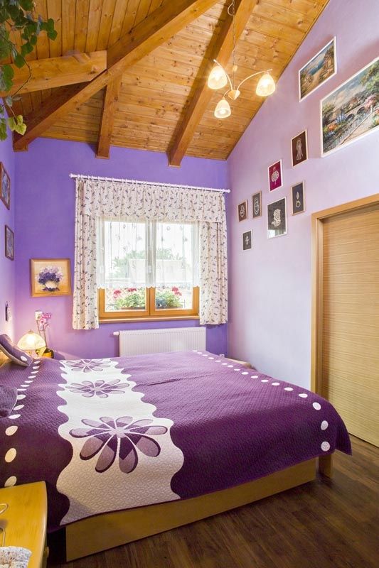 Výmalba v barvách levandule dodala ložnici příjemnou „pastelovou“ atmosféru a zvýraznila dřevěný strop.