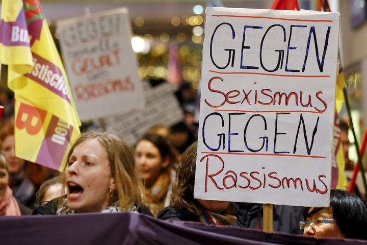 Ženy s transparenty hlásajícími hesla jako Proti sexismu, proti rasismu před nádražím v Kolíně nad Rýnem