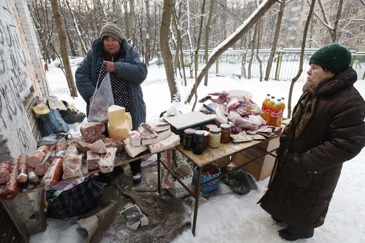 Moskvanka si prohlíží nabídku potravin u pouličního stánku.