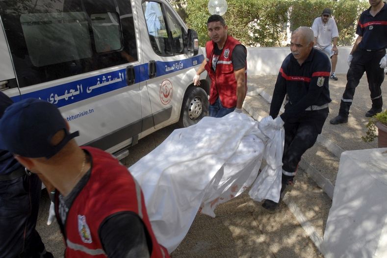 Záchranáři odnášejí tělo turisty zastřeleného při atentátu v letovisku Súsa (Sousse).