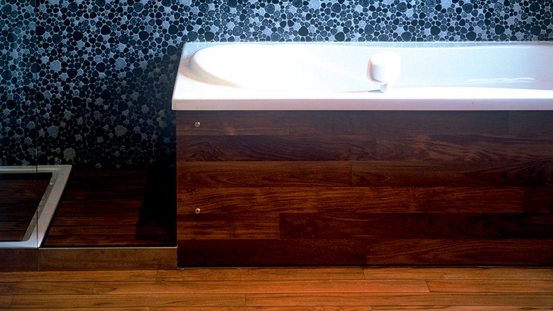 Koupelnu krášlí kvalitní dřevěná podlaha a obklad vany.