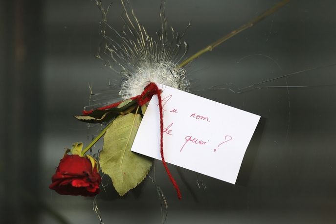 Květina se vzkazem v díře po kulce v okně restaurace v pařížské ulici Rue de Charonne