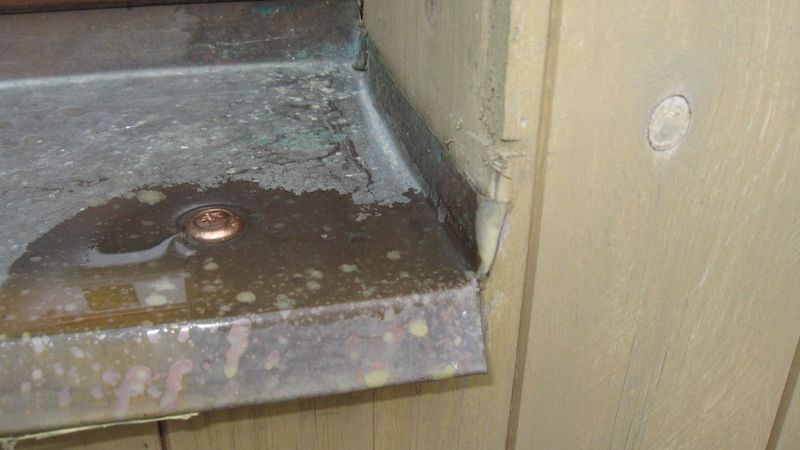 Způsob napojení parapetu na ostění a netěsný vrut v louži způsobovaly zatékání vody do dřevěné konstrukce stěny domu.