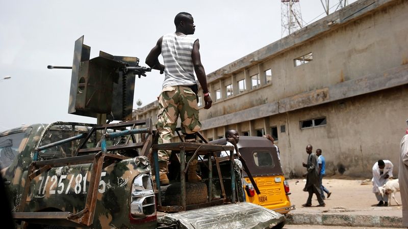 Nigerijský voják u pick-upu vybaveného kulometem 