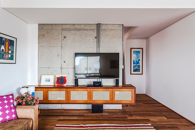 Přiznaný beton a dokonce i rozvody sítí se objevují také v televizní místnosti, která navazuje přímo na obývací pokoj.
