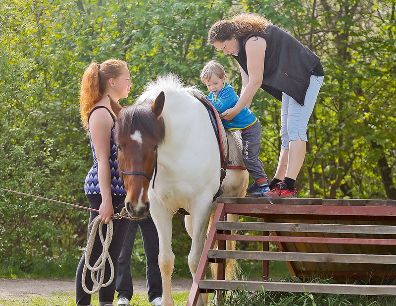 Na koně děti nasedají z dřevěné rampy.