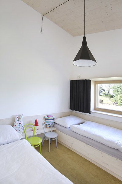 Dětský pokoj je vybaven postelemi vyrobenými na míru z běleného masivu. Lustr architekti objevili na služební cestě do Polska.