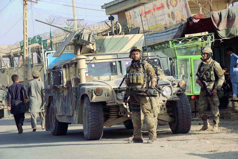 Afghánské bezpečnostní složky před obrněným vozidlem v Kundúzu