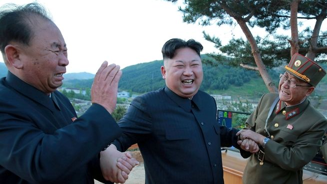 Severokorejský vůdce Kim Čong-un se raduje s raketovými experty- Vlevo je Ri Pchjong-čchol. 