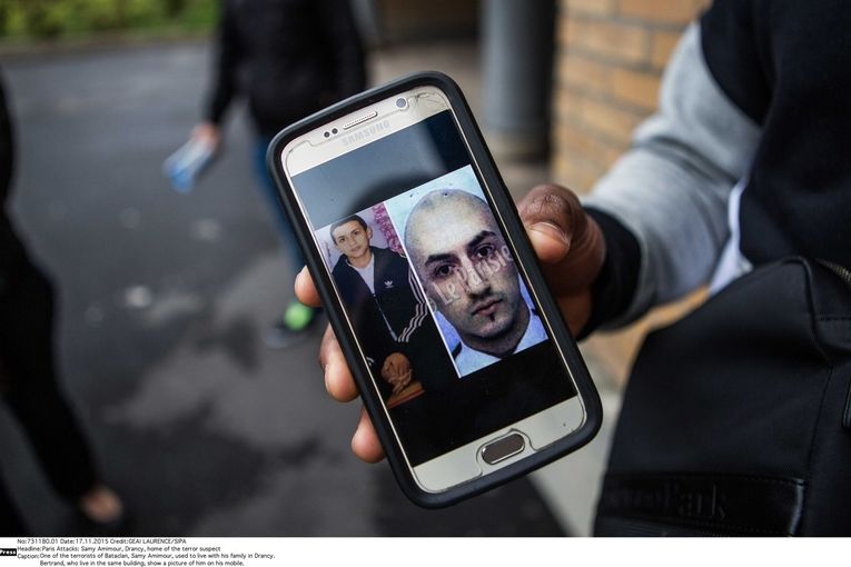 Jeden ze sousedů Samyho Amimoura ukazuje jeho fotografie uložené v mobilním telefonu.