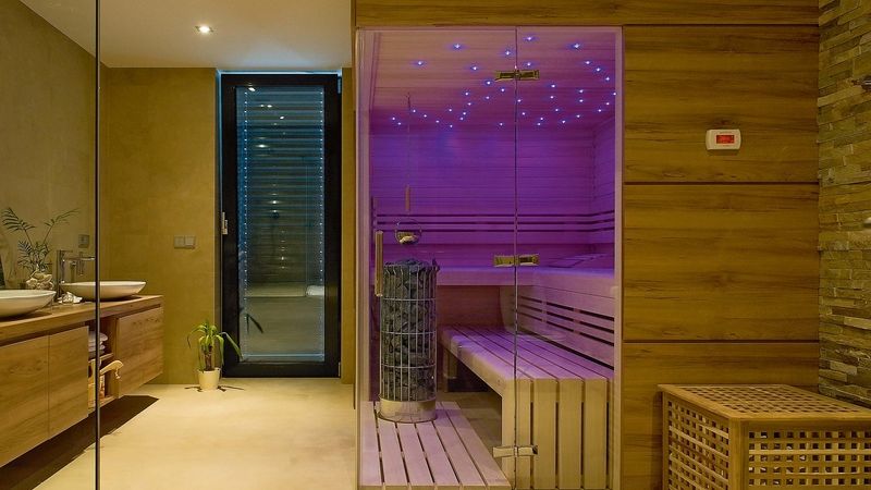 Finská sauna může být v rodinném domě i součástí koupelny. Elegantní jsou košová kamna, ale počítejme s tím, že vyhřátí trvá o něco déle. Poléváním topidla (kamenů) se zvyšuje vlhkost vzduchu. 